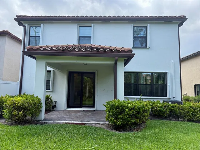 a view of a house with potted plants and a yard