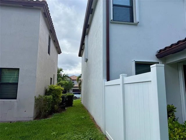 a view of a house with a big yard and potted plants