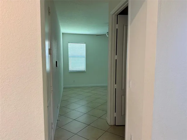 a view of a hallway with wooden floor and a living room