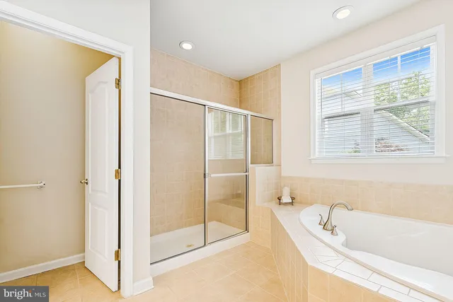 a spacious bathroom with a double vanity sink a mirror and a bathtub