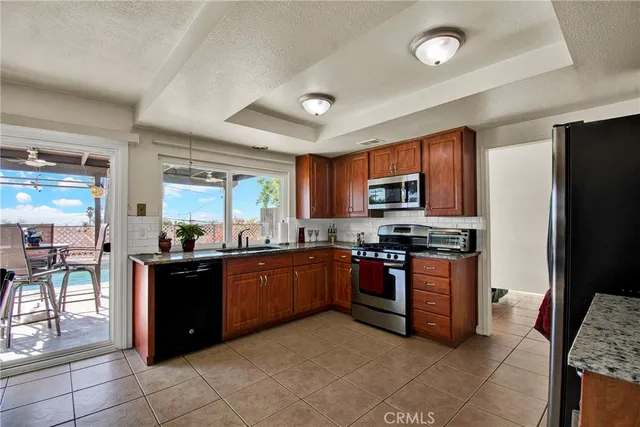 a kitchen with stainless steel appliances granite countertop a stove top oven a refrigerator and a sink