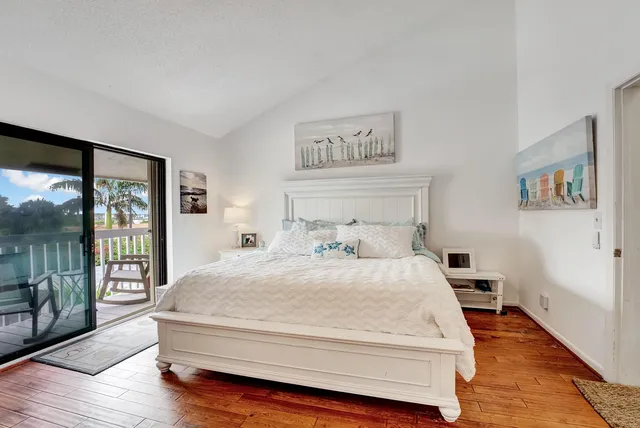 a spacious bedroom with a bed and wooden floor