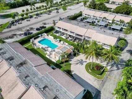 a view of a tennis ground with a large pool and potted plants