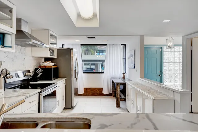 a kitchen with stainless steel appliances granite countertop a refrigerator and a stove