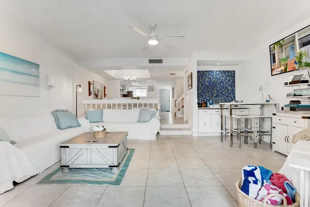 a living room with furniture and a dining table with kitchen view