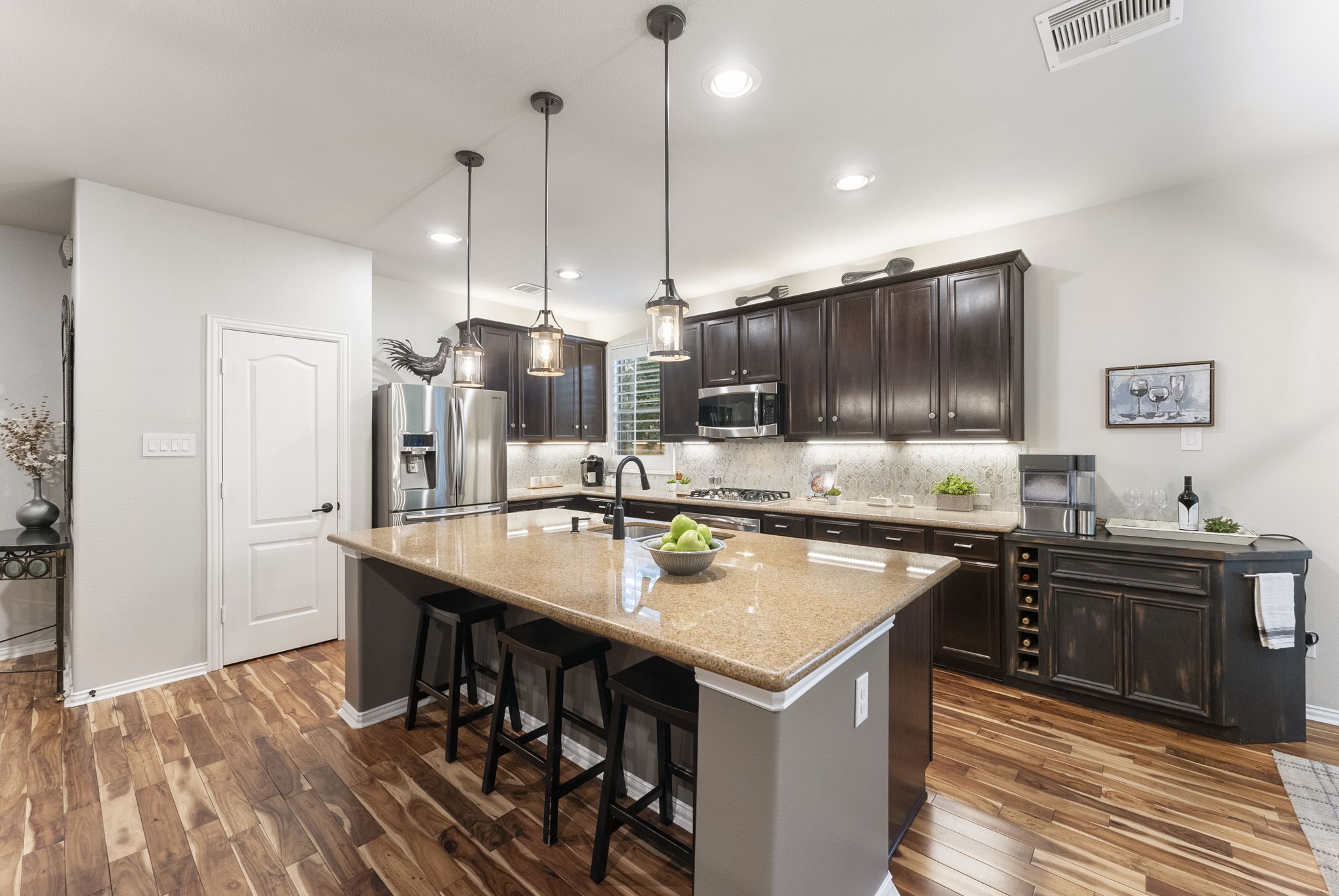 27614 Colin Springs Lane Spring, TX 77386 - Photo 13 of 47 Open kitchen showcasing wood flooring, a large island with seating, updated pendant lighting, and an inviting layout ideal for entertaining!