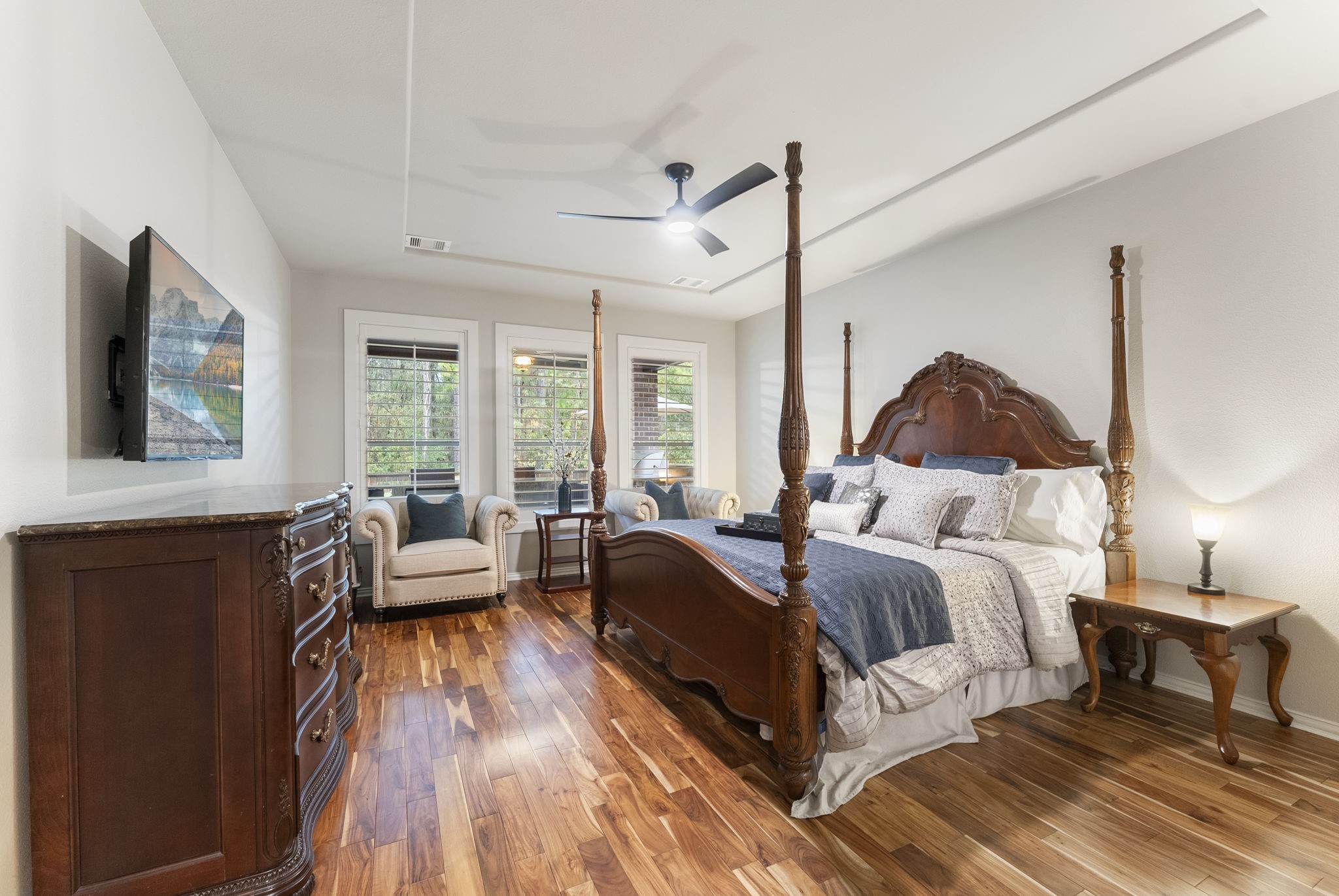 27614 Colin Springs Lane Spring, TX 77386 - Photo 18 of 47 Beautiful Primary Bedroom with wood floors, shuttered windows, a subtle tray ceiling drop, updated fan, and ample space for a cozy sitting area!