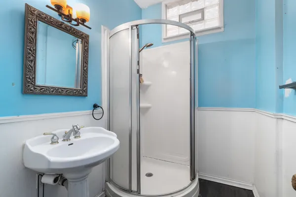 a view of an empty room with a window and a chandelier fan
