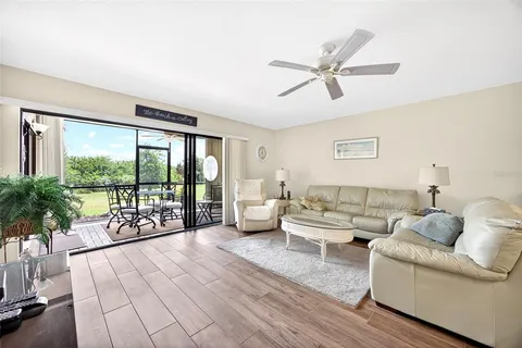 a living room with furniture and a large window with balcony view
