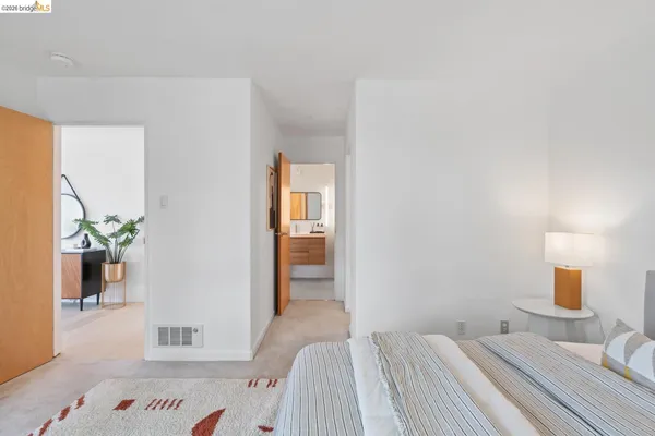 a bedroom with a bed and a potted plant