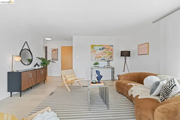 a living room with furniture a rug and white walls