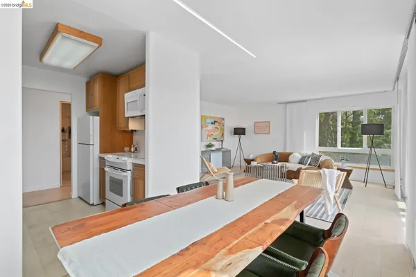 a living room with furniture a large window and wooden floor