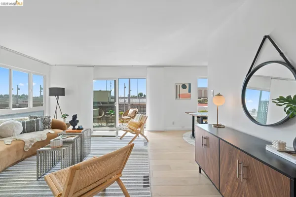 a living room with furniture a mirror and a potted plant