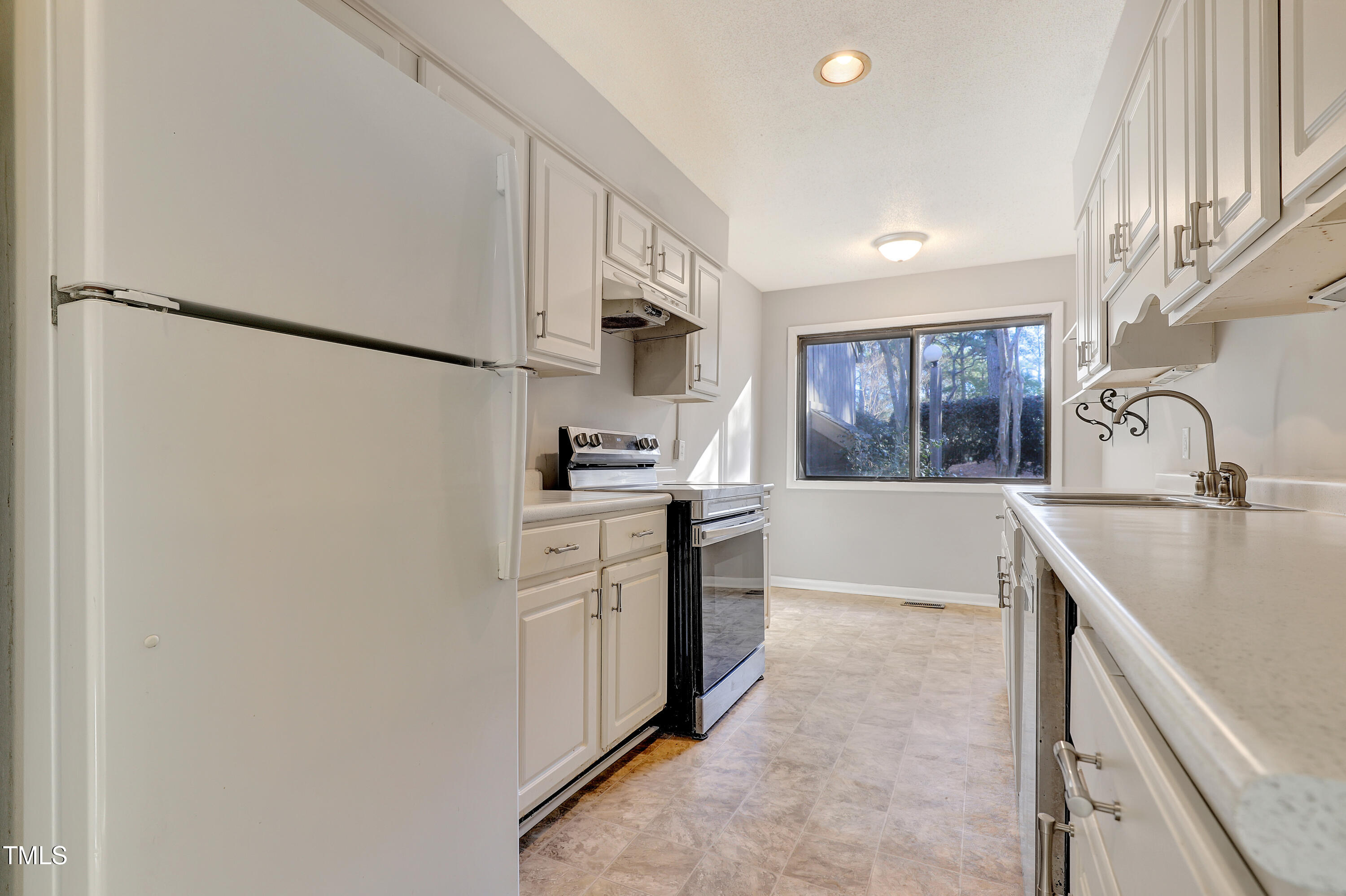 196 Ridge Trail Chapel Hill, NC 27516 - Photo 11 of 32 a kitchen with white cabinets and white appliances