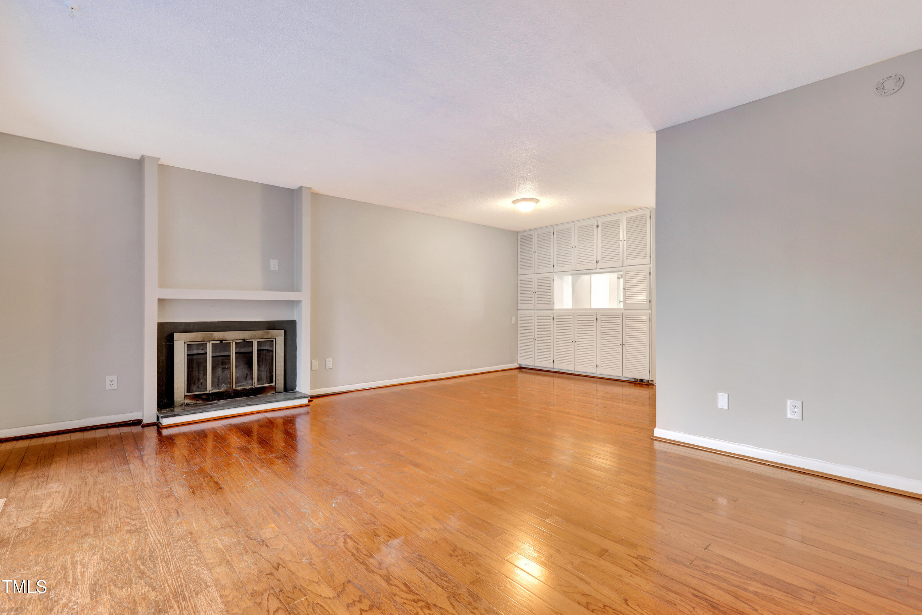 196 Ridge Trail Chapel Hill, NC 27516 - Photo 5 of 32 an empty room with wooden floor and fireplace