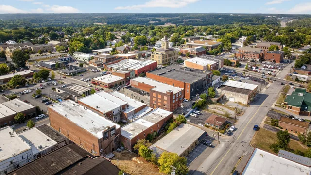 a view of living room kitchen with stainless steel appliances granite countertop a sink and cabinets
