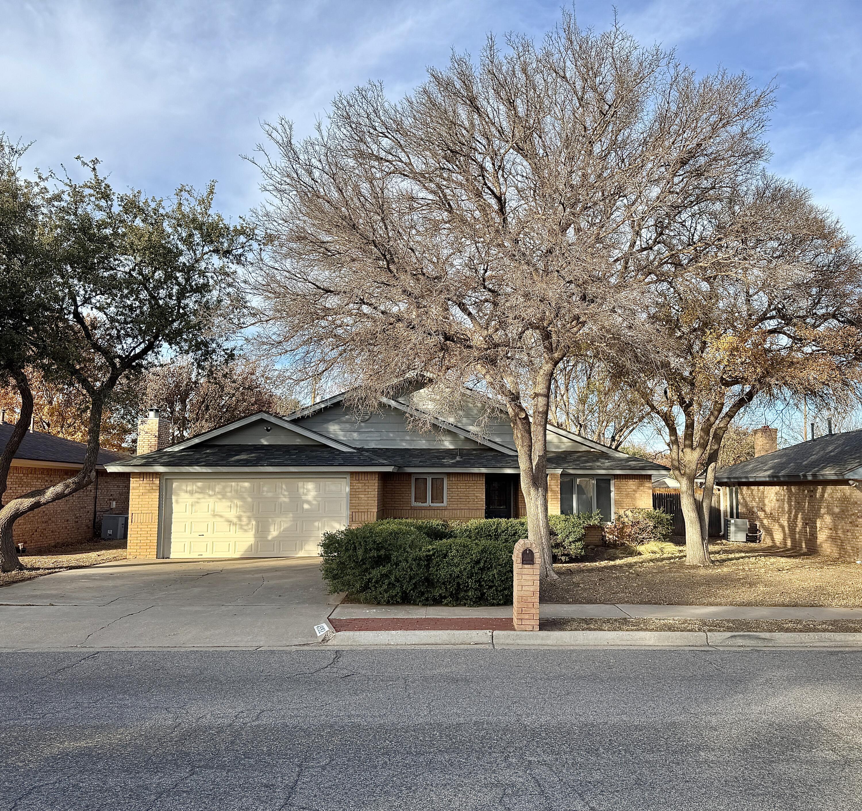 4932 63rd Street Lubbock, TX 79414 - Photo 1 of 14 a front view of a house with a yard and garage