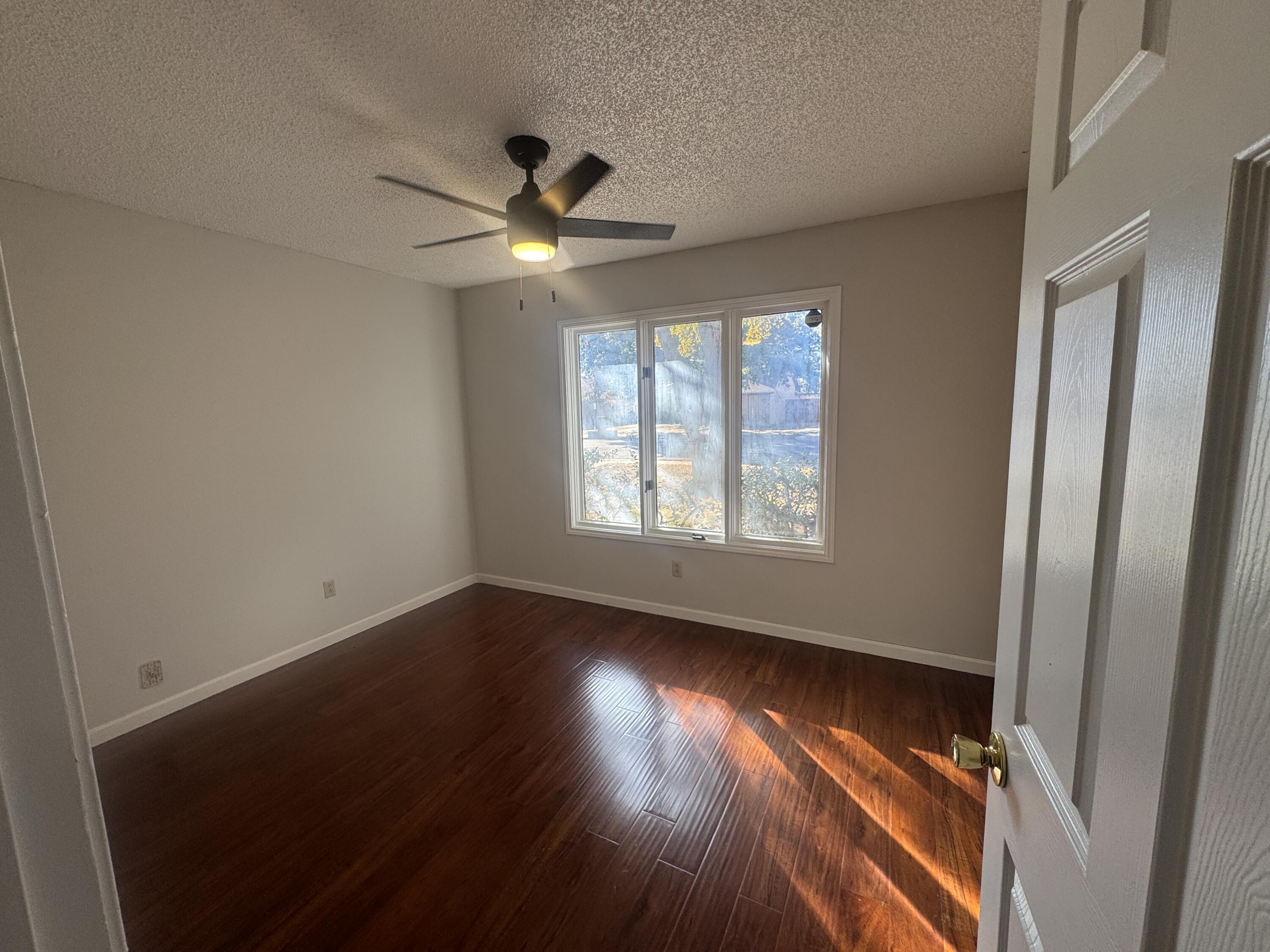 4932 63rd Street Lubbock, TX 79414 - Photo 5 of 14 a view of an empty room with wooden floor and a window