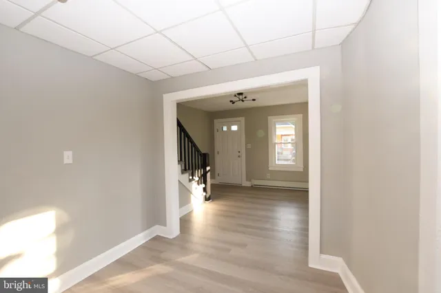 a view of hallway with stairs and wooden floor
