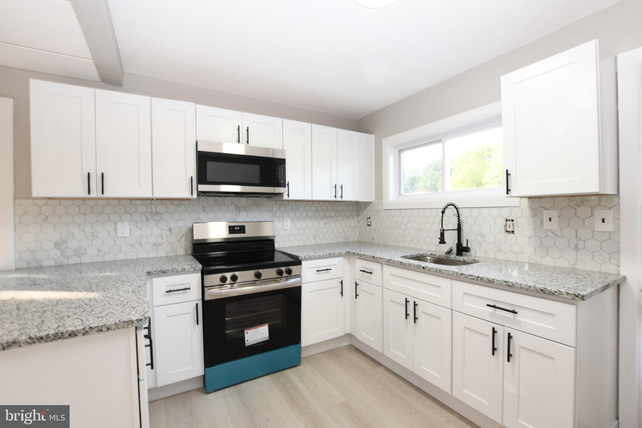14 Delaware Avenue Salem, NJ 08079 - Photo 5 of 15 a kitchen with granite countertop white cabinets sink and stainless steel appliances