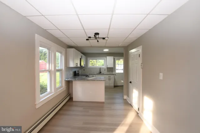 a open kitchen with stainless steel appliances granite countertop a stove a sink dishwasher and a refrigerator with wooden floor