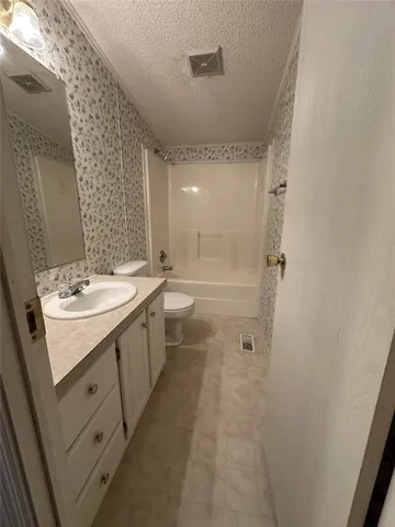 a bathroom with a double vanity sink a toilet and shower
