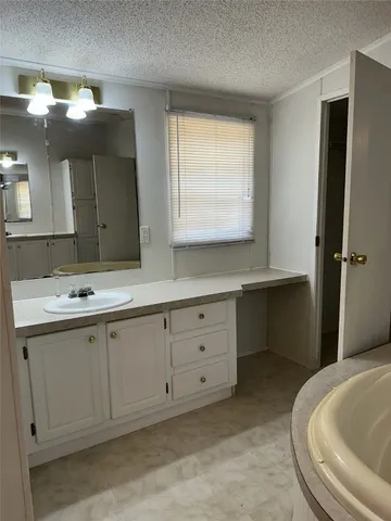 a bathroom with a tub sink and mirror