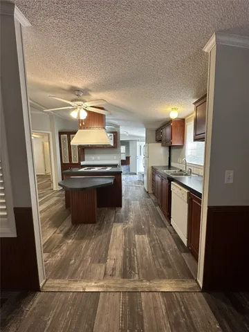 a large kitchen with a stove a sink dishwasher and a oven