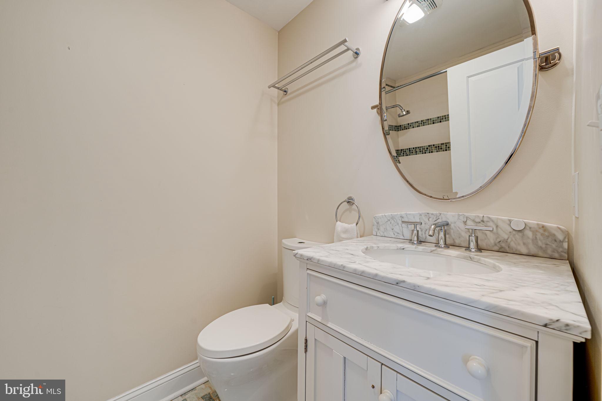 11222 Lagoon Lane Reston, VA 20191 - Photo 15 of 20 a bathroom with a granite countertop toilet sink mirror and vanity