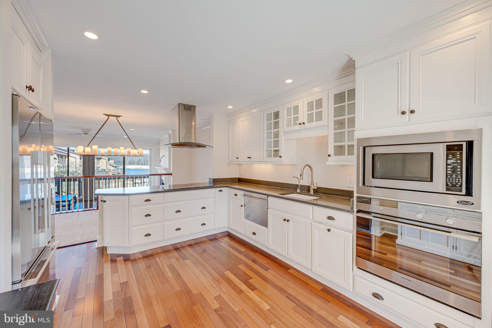 11222 Lagoon Lane Reston, VA 20191 - Photo 7 of 20 a kitchen with granite countertop a stove microwave and cabinets