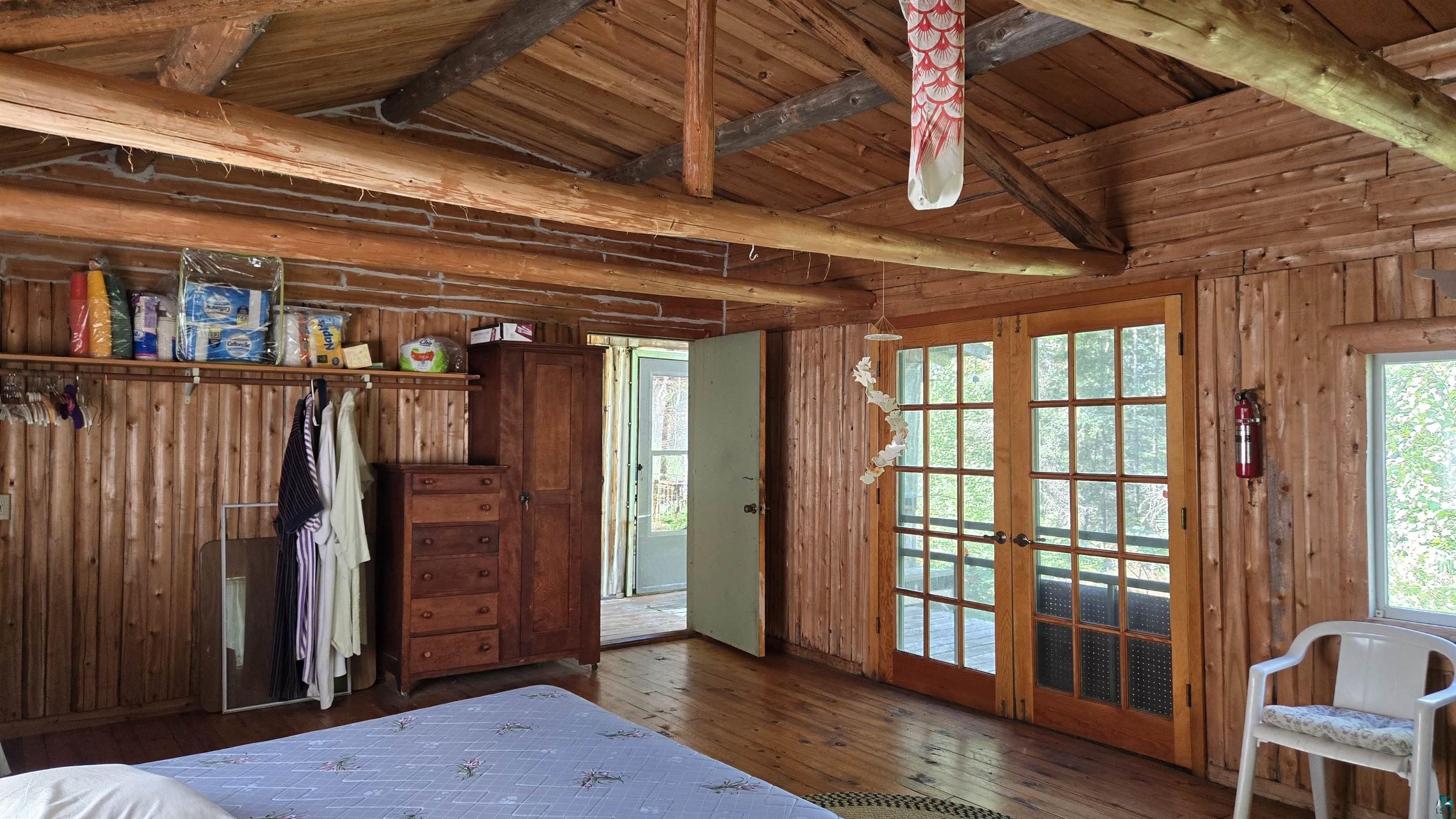 Tbd33 Tbd33 Donovan Point Orr, MN 55771 - Photo 27 of 50 Bedroom with wood walls, dark wood-style flooring, vaulted ceiling with beams, wooden ceiling, and french doors
