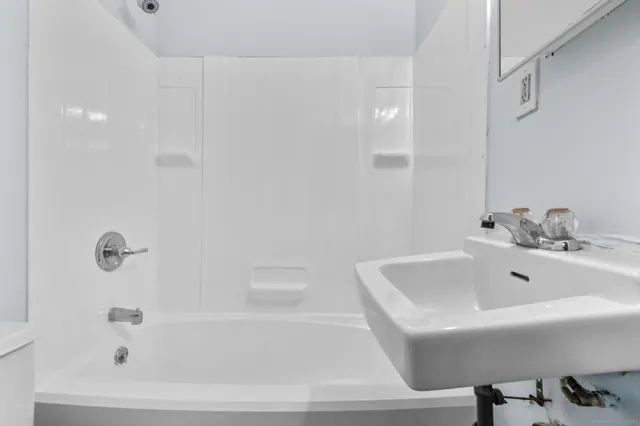 a white bath tub sitting next to a white sink