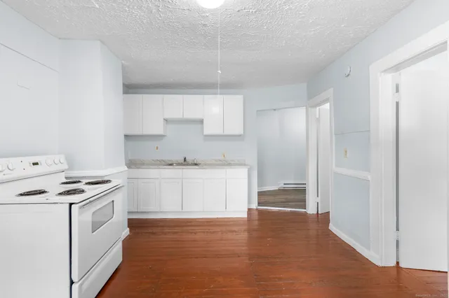 a kitchen with stainless steel appliances a stove a sink and white cabinets