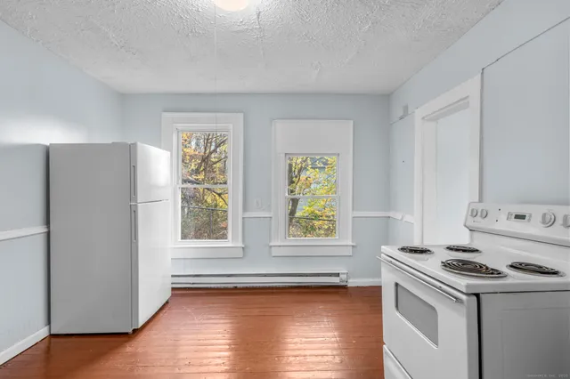 a kitchen with a stove a refrigerator and a window