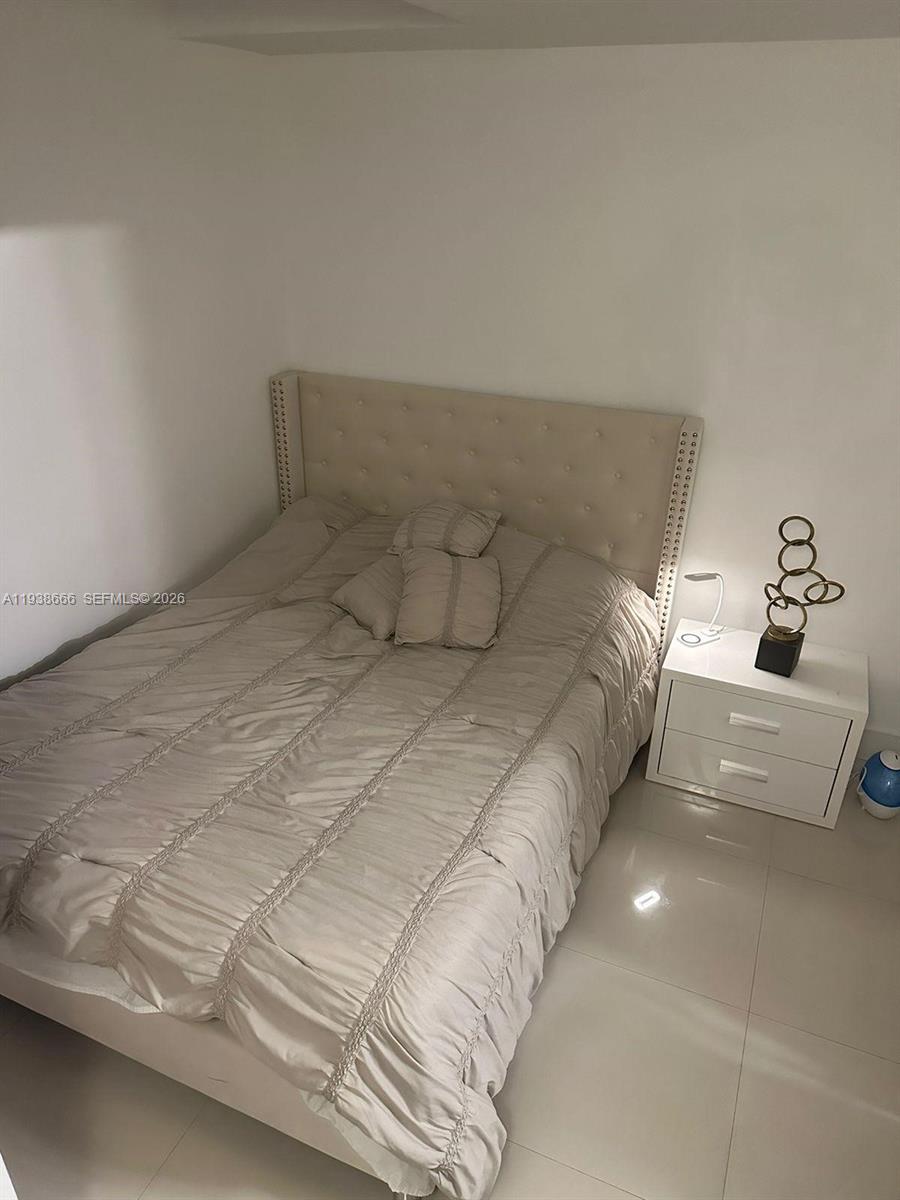 60 Southwest 13th Street, Unit 2422 Miami, FL 33130 - Photo 15 of 33 a bedroom with a bed and a couch