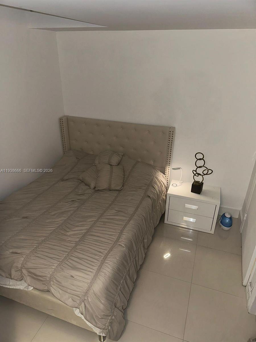 60 Southwest 13th Street, Unit 2422 Miami, FL 33130 - Photo 16 of 33 a bedroom with a bed and a night stand
