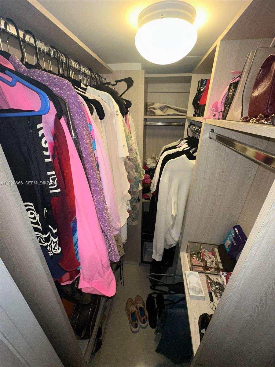 60 Southwest 13th Street, Unit 2422 Miami, FL 33130 - Photo 17 of 33 a view of walk in closet with clothes and shoes