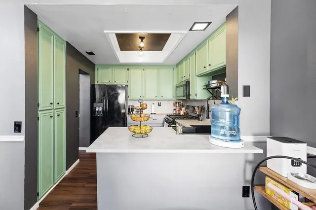 a open kitchen with stainless steel appliances granite countertop a refrigerator and a stove