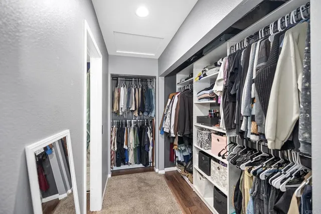 a view of walk in closet with clothes and shoes