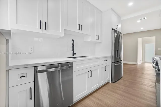 a kitchen with stainless steel appliances a refrigerator and a sink
