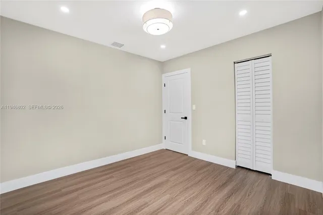 a view of an empty room with wooden floor