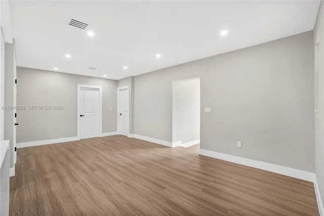 a view of an empty room with wooden floor