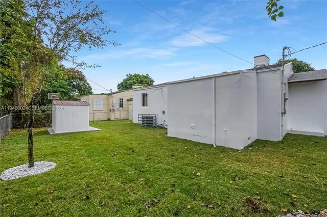 a view of a backyard with potted plants and large tree