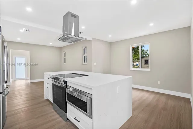 a kitchen with a stove and a wooden floor