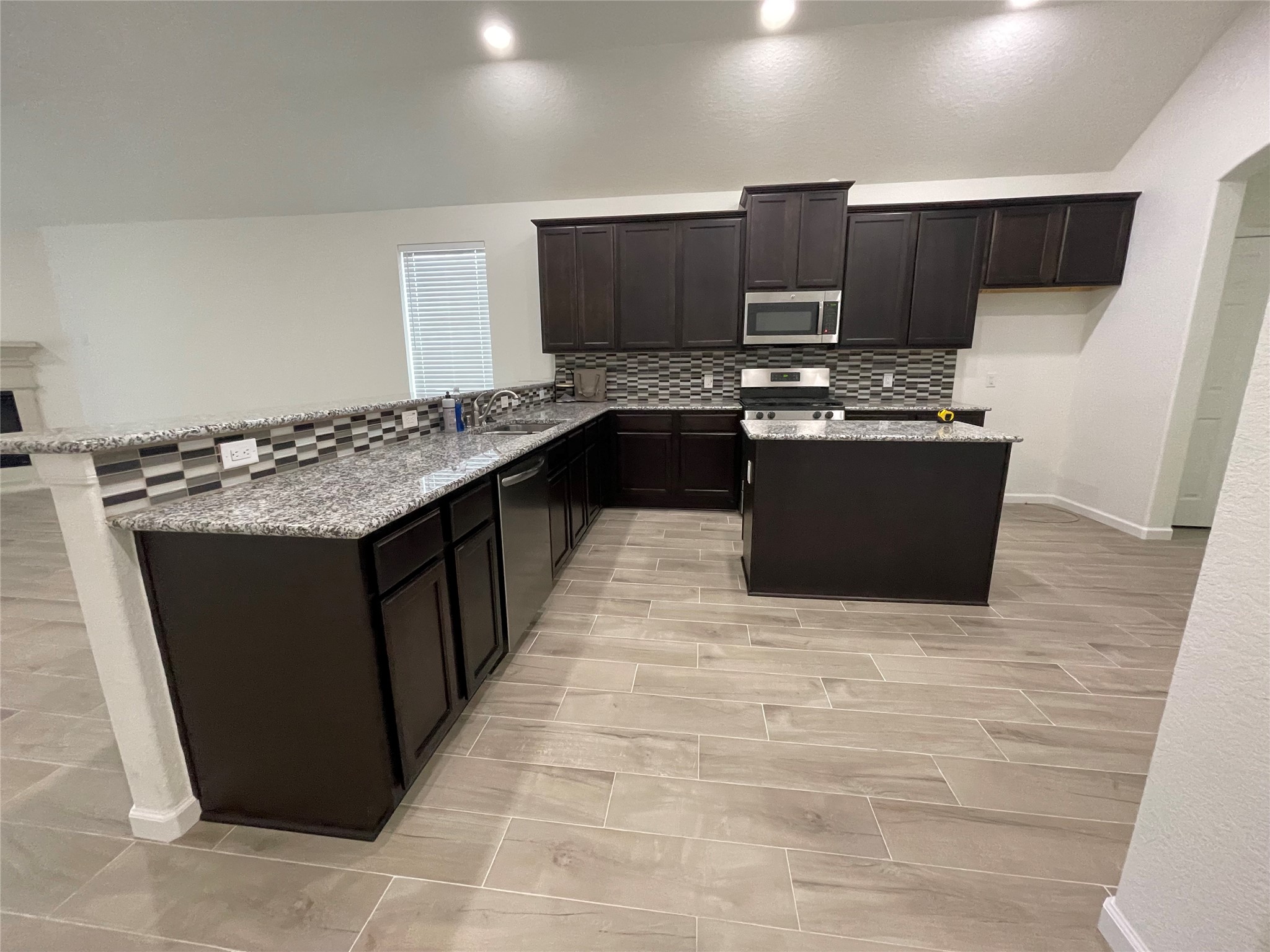 4118 Guild Meadows Drive Houston, TX 77084 - Photo 18 of 35 a kitchen with stainless steel appliances granite countertop a stove a sink and a microwave