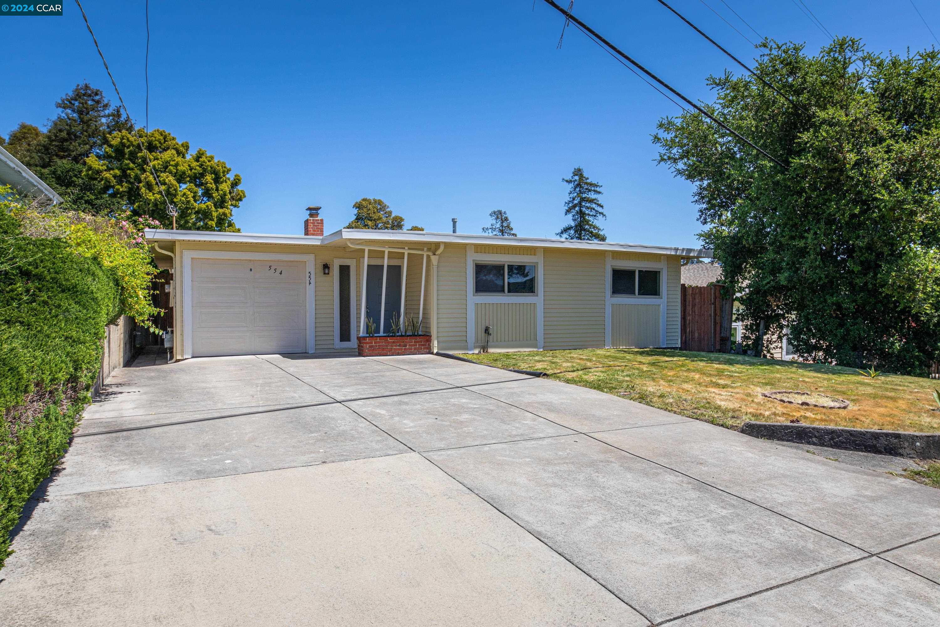 a view of a house with a yard and potted plants