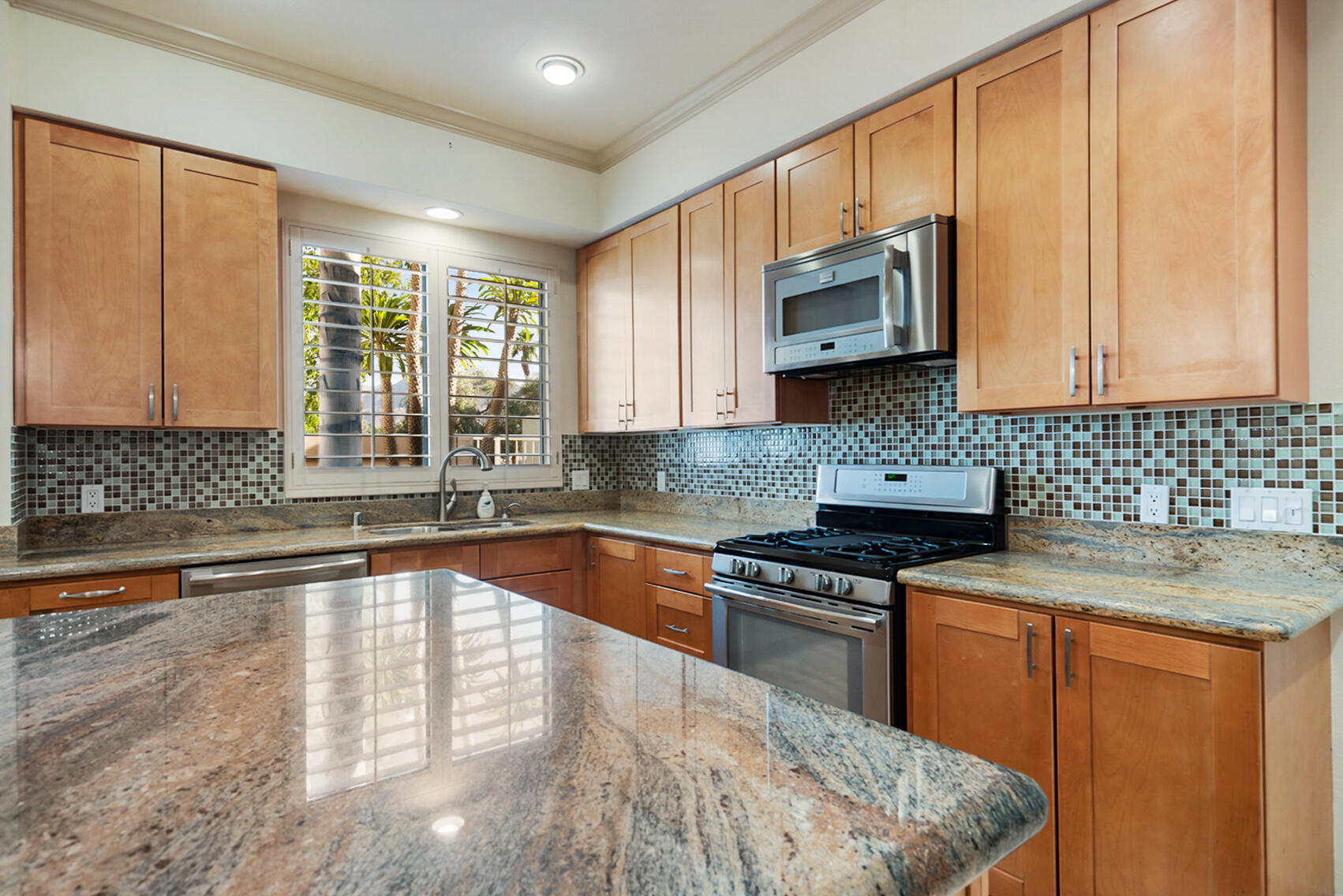 137 Desert W Drive Rancho Mirage, CA 92270 - Photo 17 of 56 a kitchen with stainless steel appliances granite countertop a sink stove and microwave