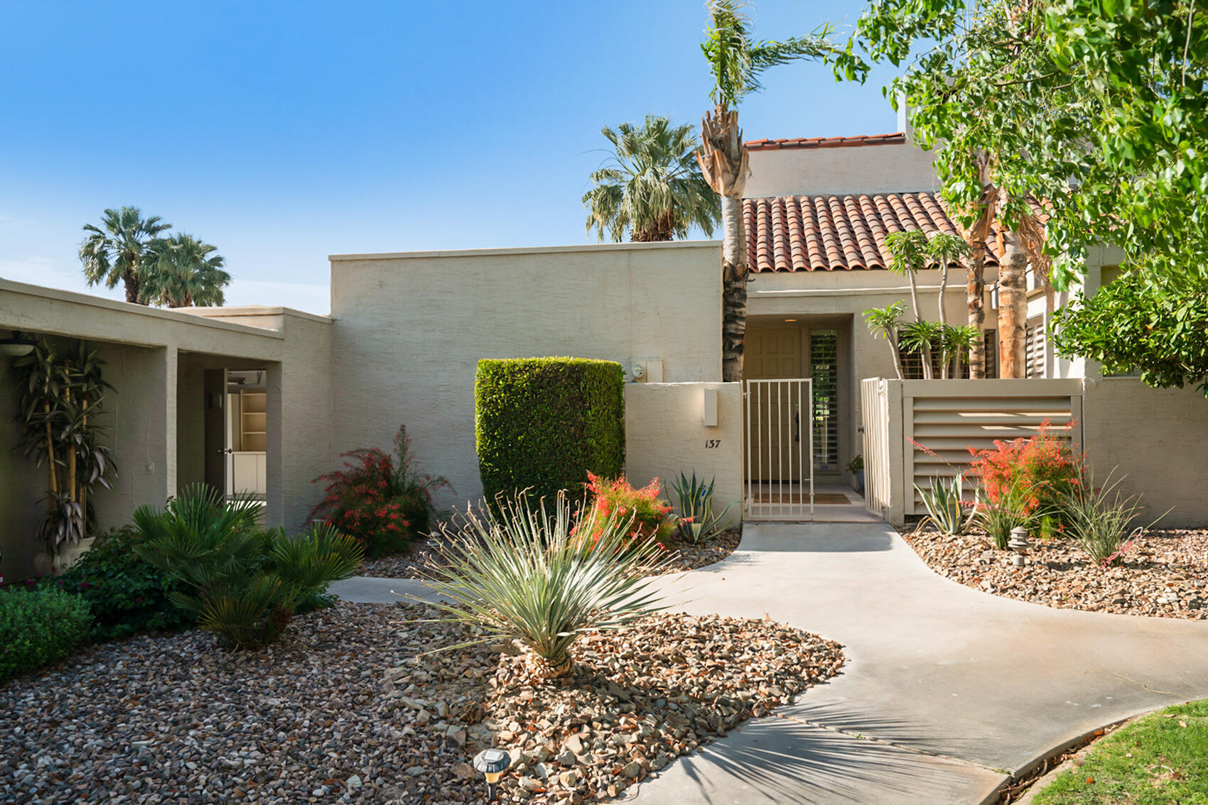 137 Desert W Drive Rancho Mirage, CA 92270 - Photo 49 of 56 a front view of a house with a garden