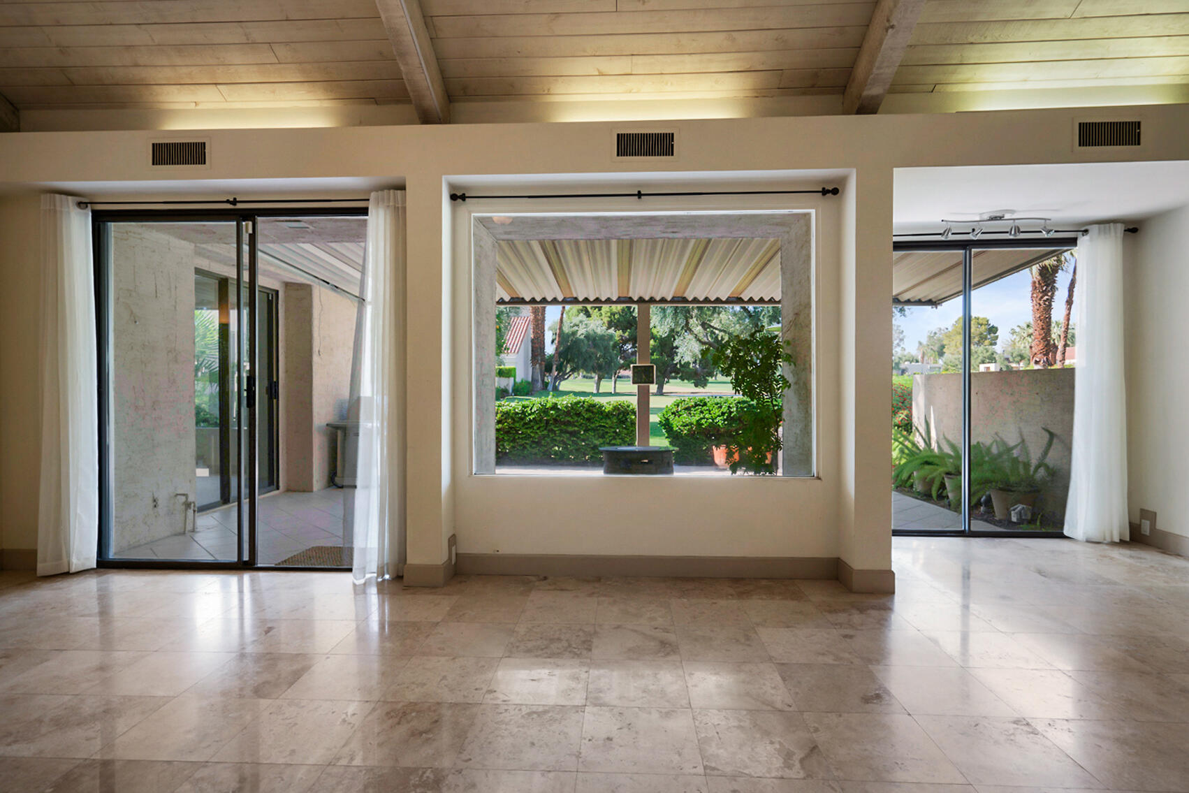 137 Desert W Drive Rancho Mirage, CA 92270 - Photo 6 of 56 a view of an empty room with wooden floor and a window