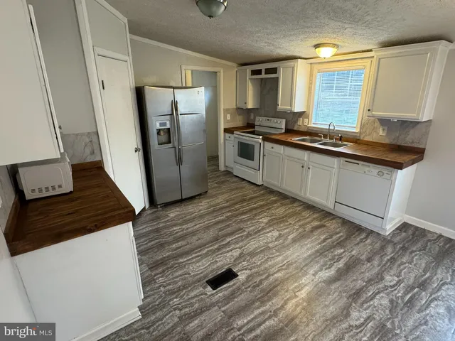 a kitchen with stainless steel appliances a refrigerator a sink a stove and cabinets